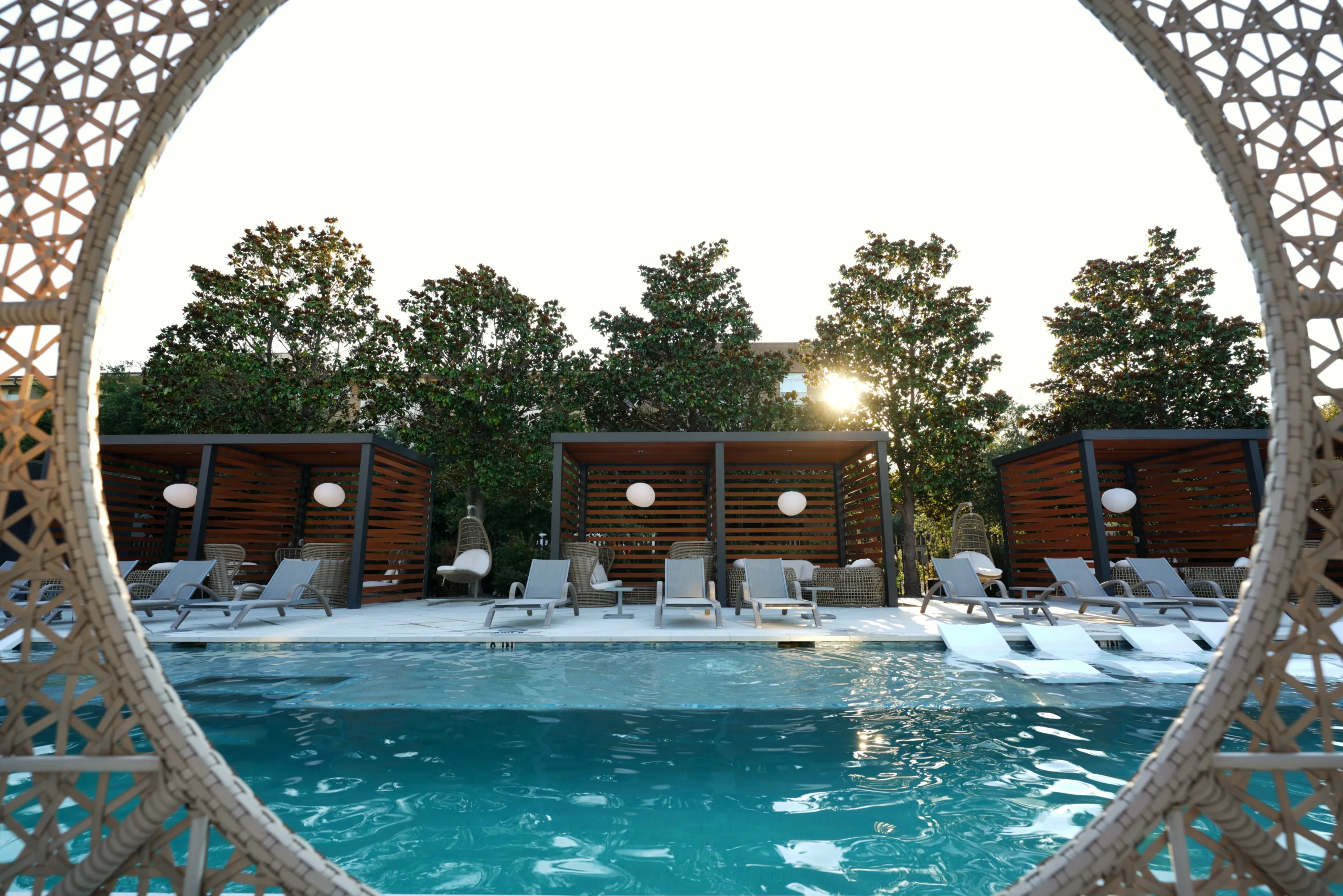 Wood-slat poolside cabanas in a luxury resort setting