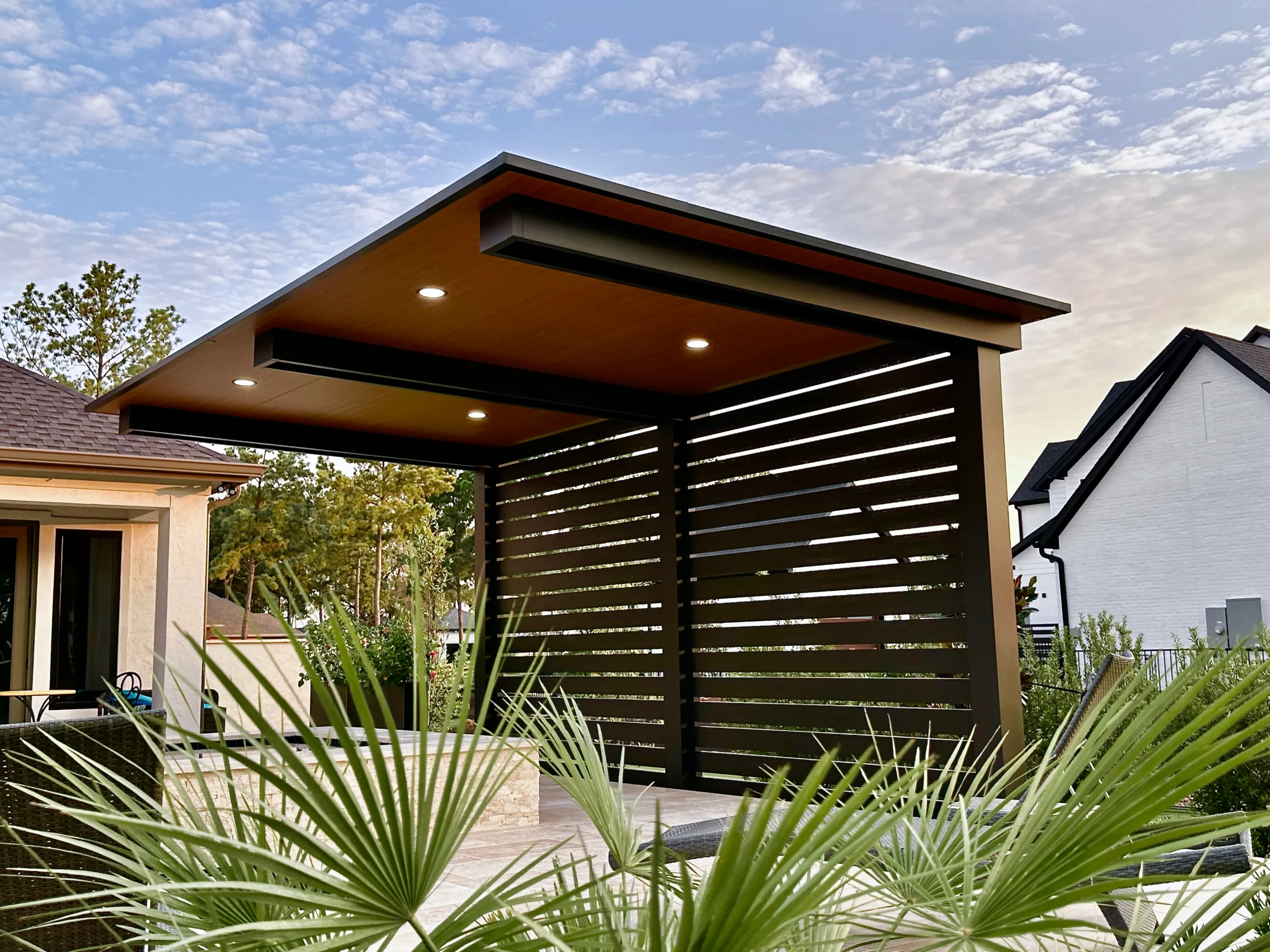 Vertical-slat cantilever over a private patio