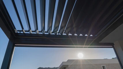 Adjustable louvered roof system over a modern patio